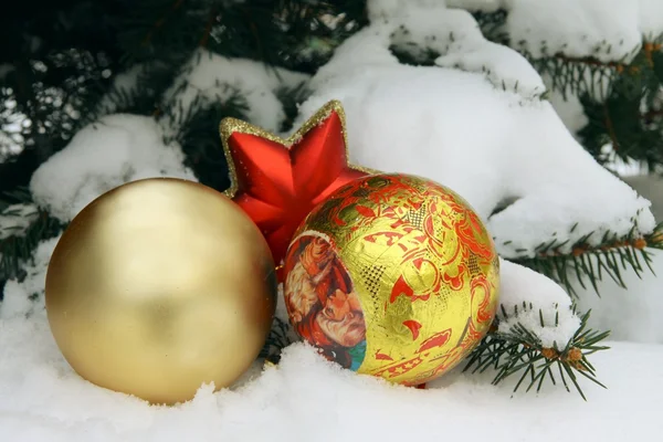 Рождественские украшения на снежной елочной веточке — стоковое фото