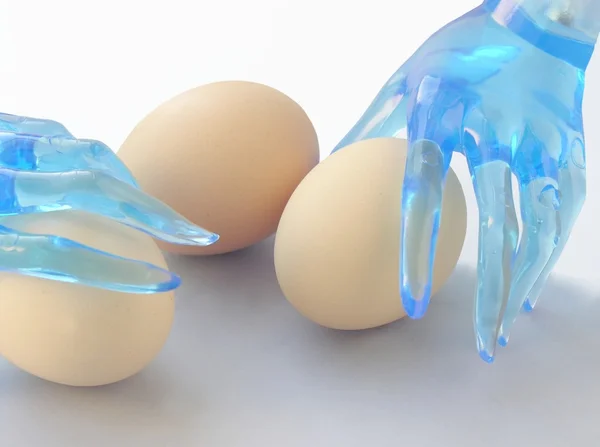 Eggs and blue hands — Stock Photo, Image