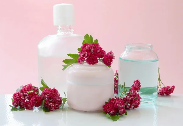 Kvinnliga kosmetika och rosa blommor — Stockfoto