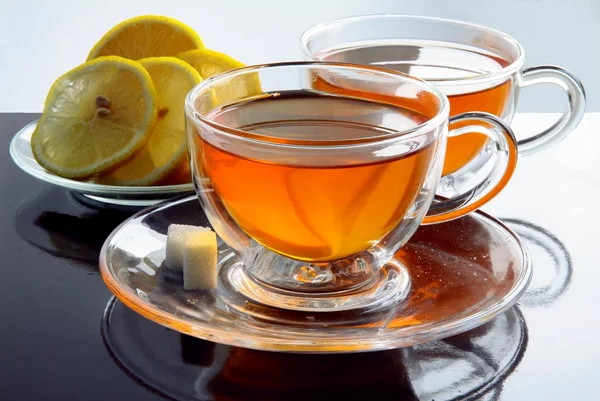 Чашки чая и ломтики лимона — стоковое фото