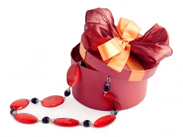 Červená kulatá krabice s náhrdelník jako dárek — Stock fotografie