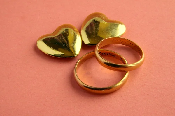 Anéis de ouro do casamento e coração como símbolo de amor e casamento — Fotografia de Stock