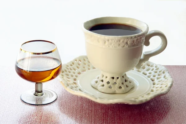 Tasse schwarzen Kaffee und Brandy im Glas — Stockfoto