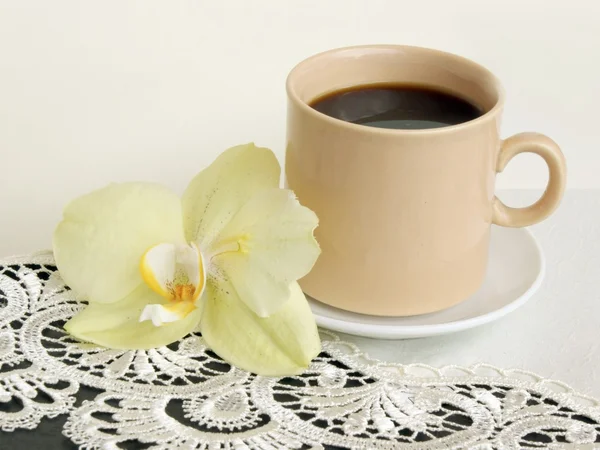 Kubek czarny gorący kawa i żółty kwiat orchidei — Zdjęcie stockowe