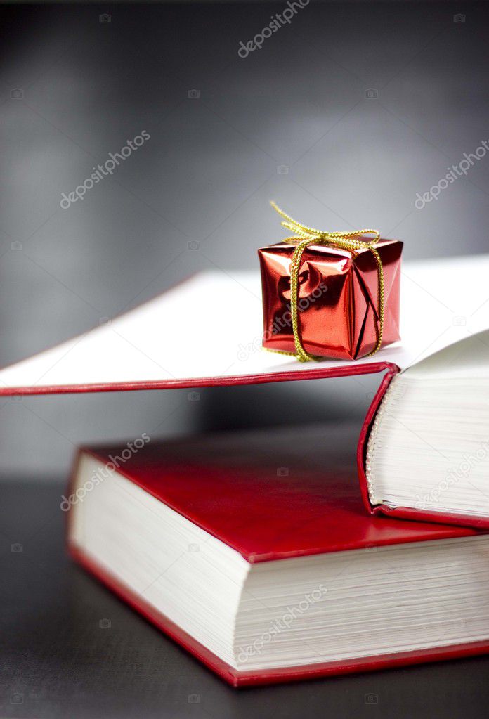 A present lying on two books on a black background