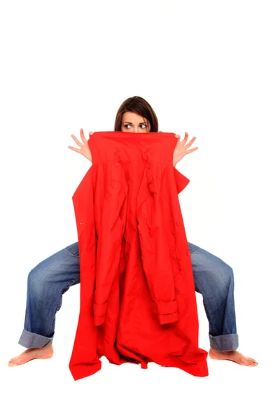 Девушка в джинсах держит красное пальто — стоковое фото