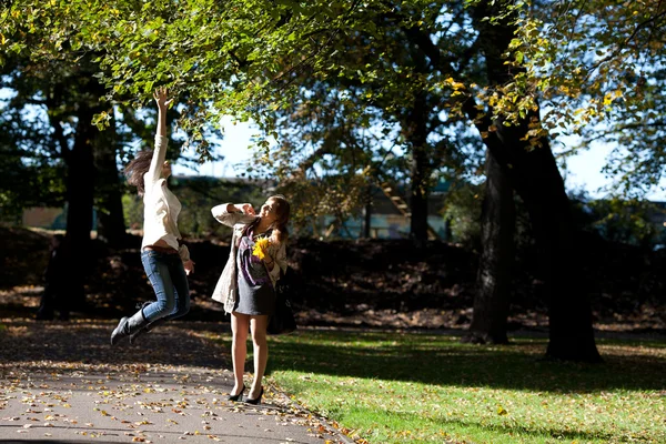 Duas jovens brincam no parque de outono — Fotografia de Stock