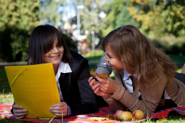 Deux jeunes filles assises dans le parc d'automne — Photo