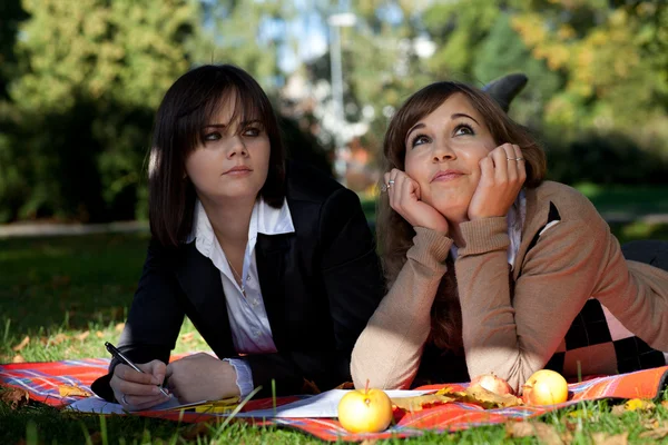 Deux jeunes filles assises dans le parc d'automne — Photo