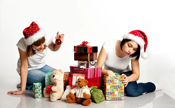 Two smiling christmas girls unpacking gifts — Stock Photo, Image