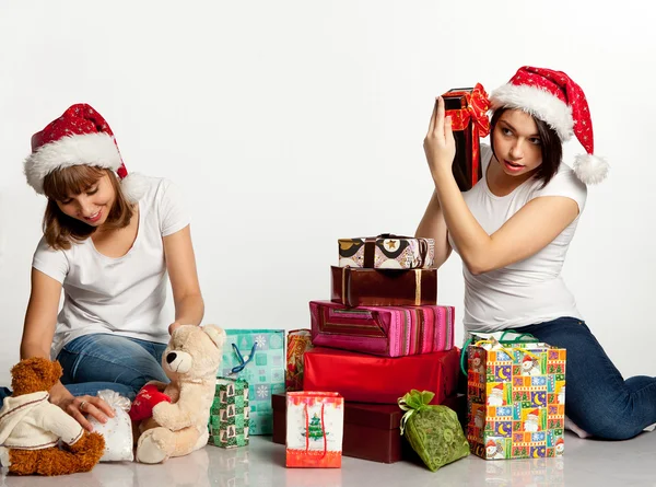 Due sorridenti ragazze di Natale disimballano i regali — Foto Stock