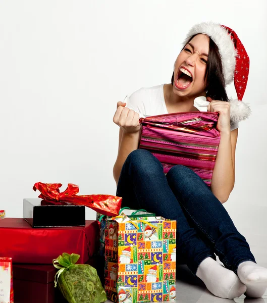 Lächeln verblüffte Weihnachtsmädchen beim Auspacken von Geschenken. isoliert auf weiß Stockbild