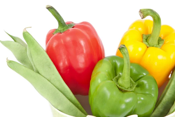 Zelené fazolky s žluté, zelené a červené papriky na bílém pozadí — Stock fotografie