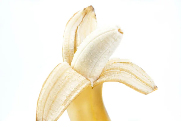 Yellow banana with the peel removed isolated on white — Stockfoto