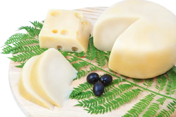 Species of cheeses on a wooden board with black olives. — Stock Photo, Image