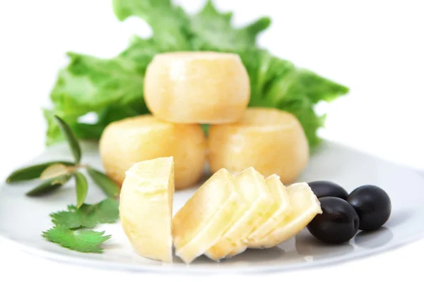 Arten von Käse auf einem Holzbrett mit schwarzen Oliven. — Stockfoto