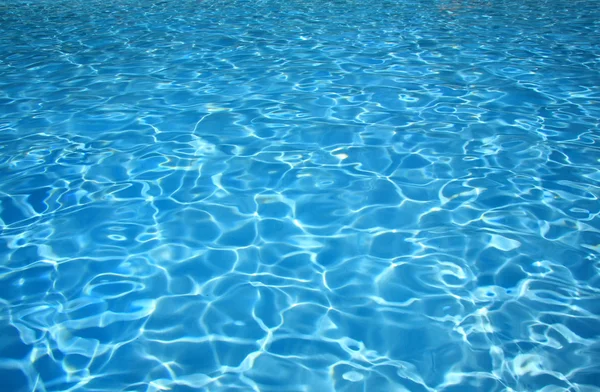 清澈的游泳池中的蓝色水 图库照片