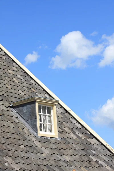 Op het dak met venster en een blauwe hemel Rechtenvrije Stockafbeeldingen