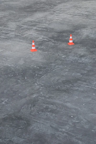 Twee rubber verkeer kegels op grijs asfalt — Stockfoto