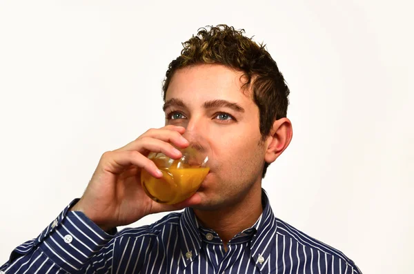 Attractive young man drinking fruit juice — Stock Photo, Image