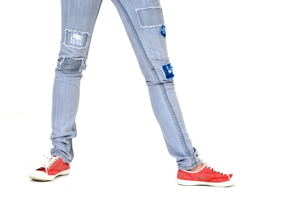 Red sneakers and patched jeans — Stock Photo, Image