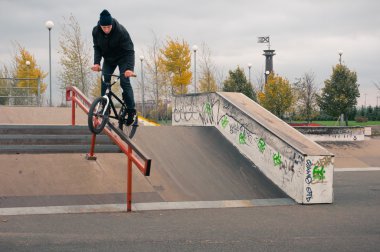 Biker doing crank slide grind trick clipart