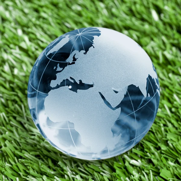 Globus erdball geo karte glas kristal blau fussball rasen — Stock fotografie