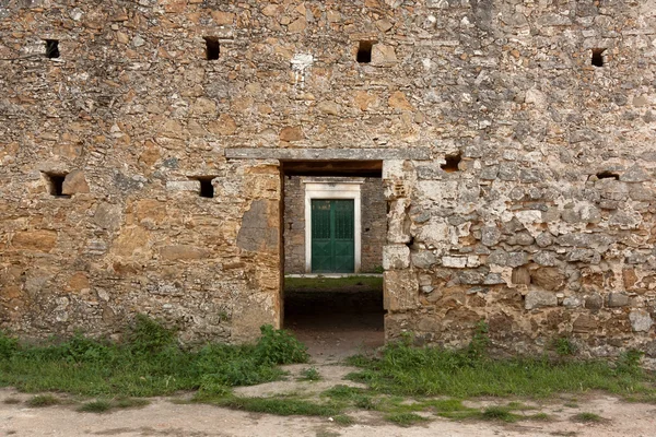 Parede de pedra velha com porta verde para dentro — Fotografia de Stock