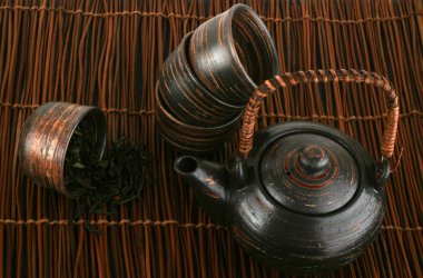 Tea-set with green tea on a brown background clipart