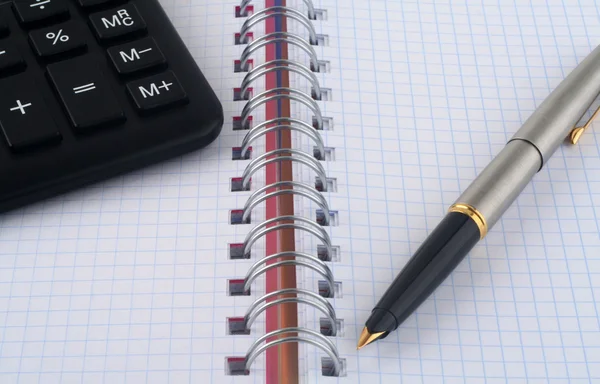 Kalkulačka a pero na bílém pozadí — Stock fotografie