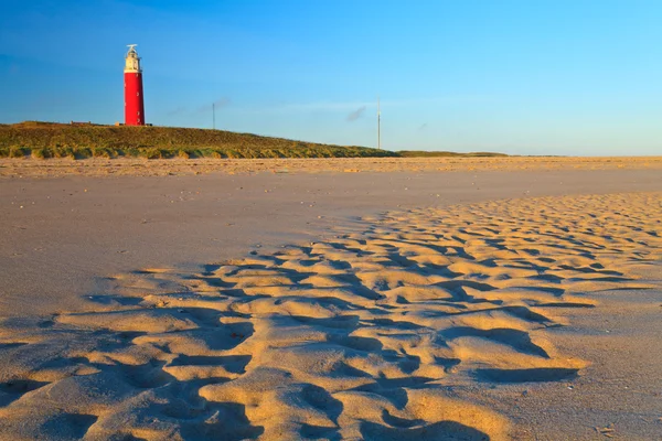 Seaside with sand dunes and lighthouse at sunset — Stock Photo, Image