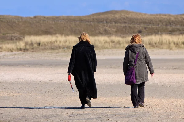 stock image Women walking in the sand dunes on the beach