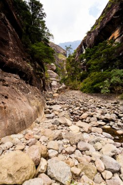 Dry riverbed with mountains in the background clipart