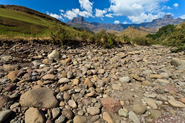 Torr flodbädd med bergen i bakgrunden — Stockfoto