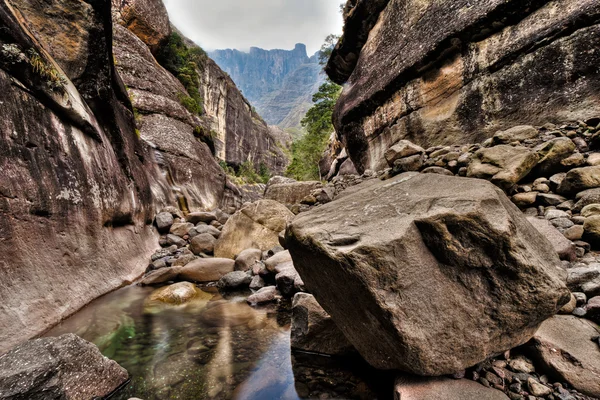 Letto di fiume asciutto con montagne sullo sfondo — Foto Stock