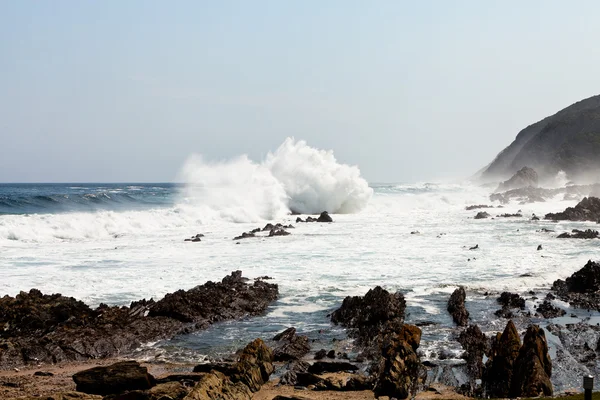 Висока хвиля, що ламається на скелях — стокове фото