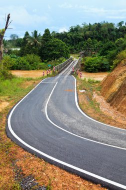 kahverengi bir nehir üzerinde köprü olan yol