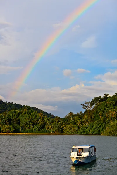 Цветная радуга над тропическим пляжем — стоковое фото