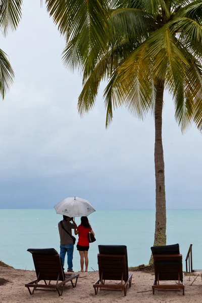 Couple on the beach staring at the sea — Stock Photo, Image
