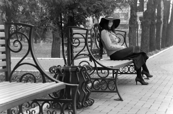 Dívka sedí na lavičce — Stock fotografie