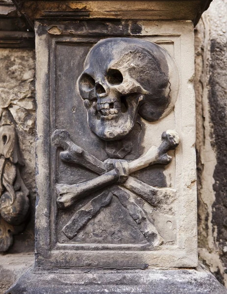 Lebka a zkřížené kosti na náhrobku — Stock fotografie
