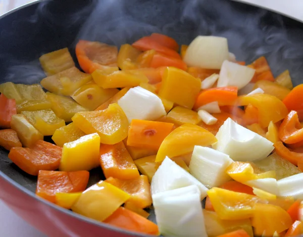 Pimentos e cebolas cozinhando em frigideira — Fotografia de Stock