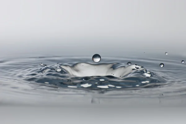 Schoon druppel water spatten in helder water. abstracte productiemethoden — Stockfoto