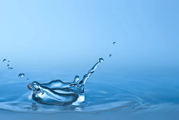 Чистая голубая капля воды брызгает в чистой воде. Абстрактный синий — стоковое фото