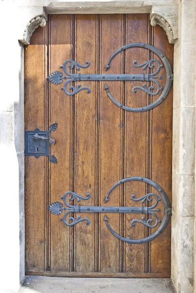 stock image Crafty wooden door with metal ornament and metal handle