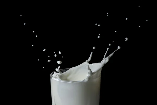 Абстрактне молоко плескає на чорному тлі — стокове фото