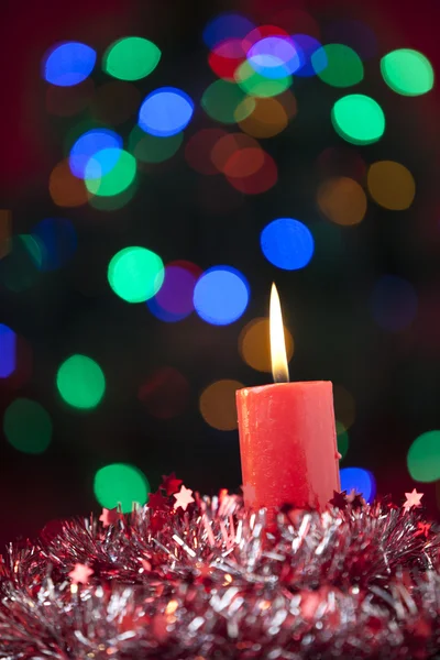 Christmas candle with colorful lights background — Stock Photo, Image