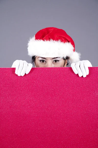 Frau mit Weihnachtsmütze und leerem Schild — Stockfoto
