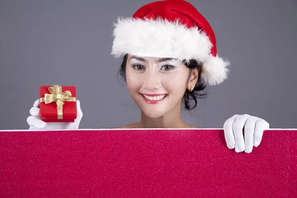 Hermosa mujer con un signo en blanco y un regalo de Navidad — Foto de Stock