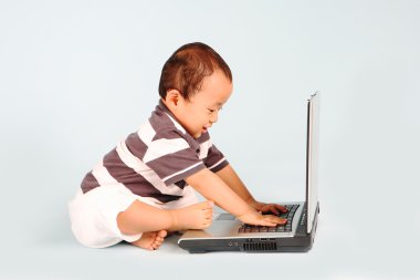 bir dizüstü bilgisayar kullanarak mutlu yürümeye başlayan çocuk